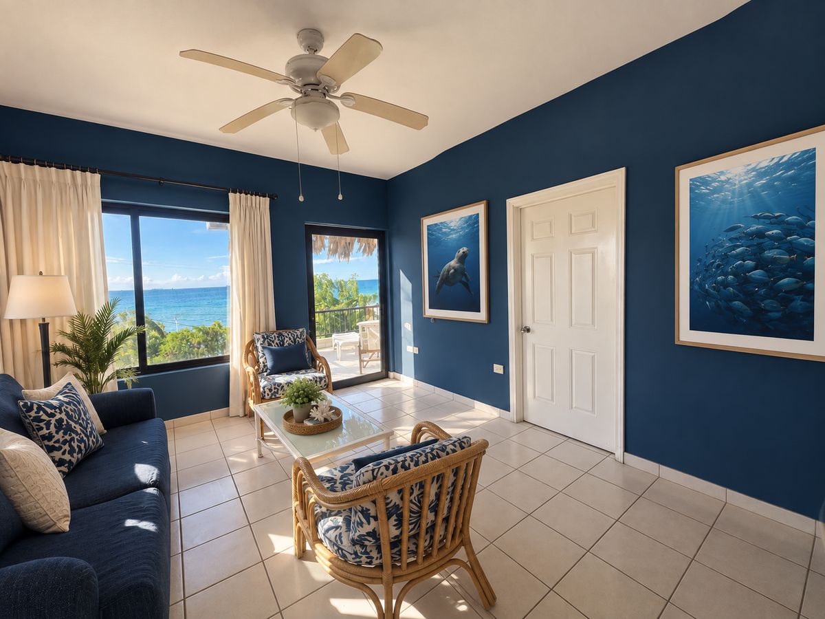 Ocean Suite living room with the sea through the windows and a framed school of fish