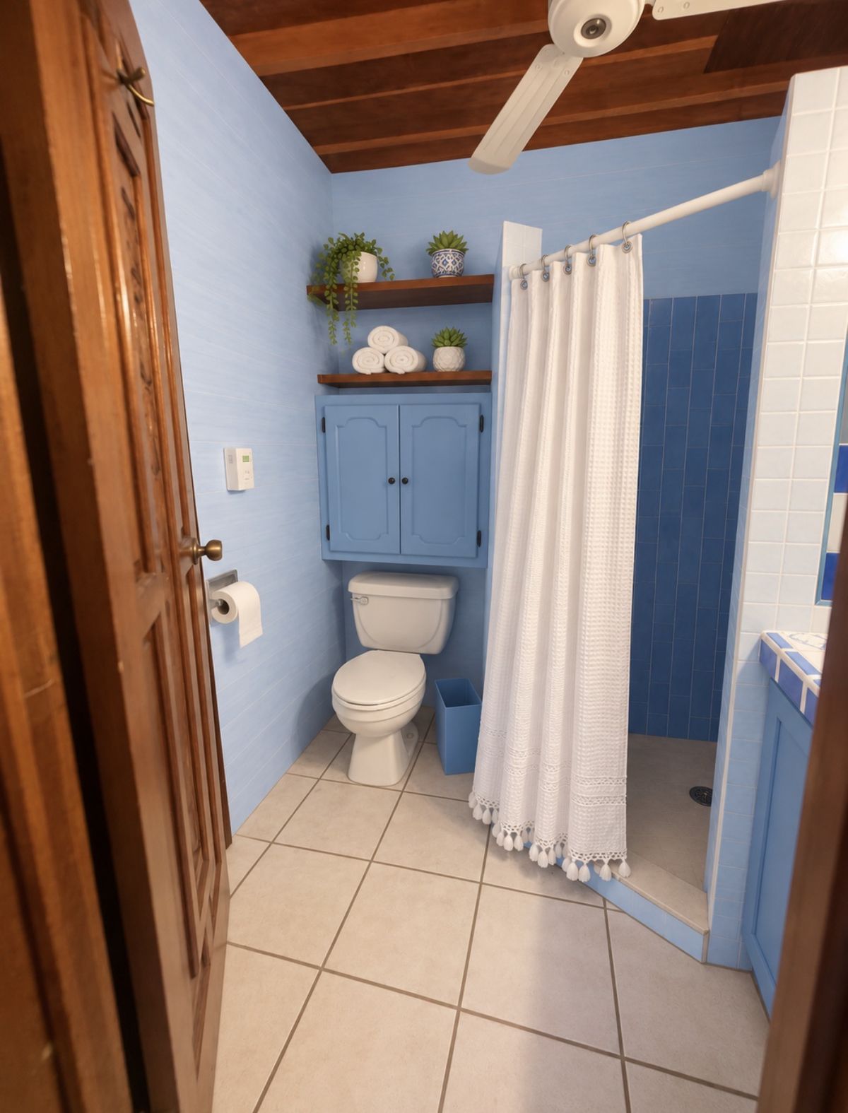 Wave Room bathroom seen from the doorway, with sky-blue walls and a white shower curtain